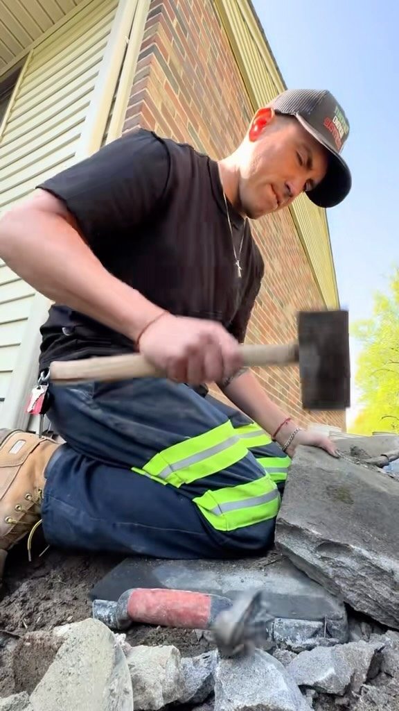 Alex Sansalone splitting stone with a hammer