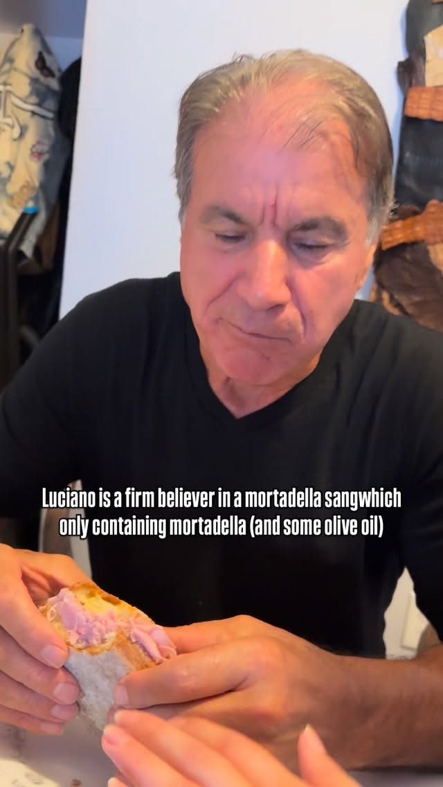 Luciano Sansalone enjoying a mortadella sandwich
