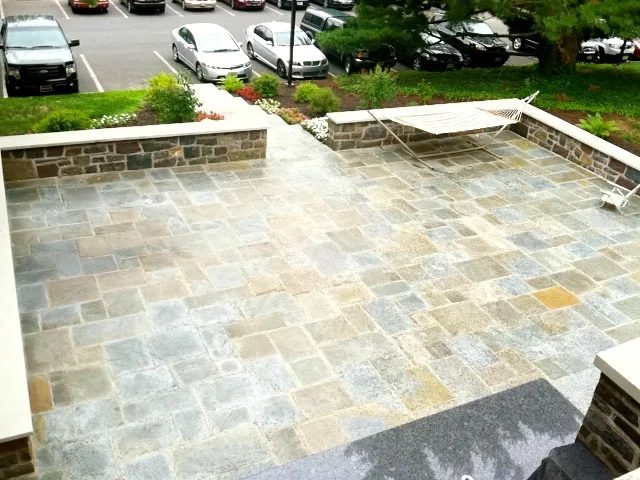 Bluestone patio with a low stone wall