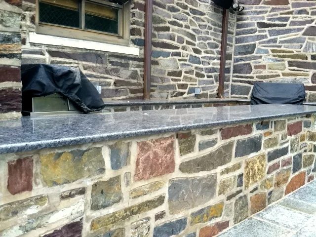 Close-up of a fieldstone wall pointed tight under a granite cap